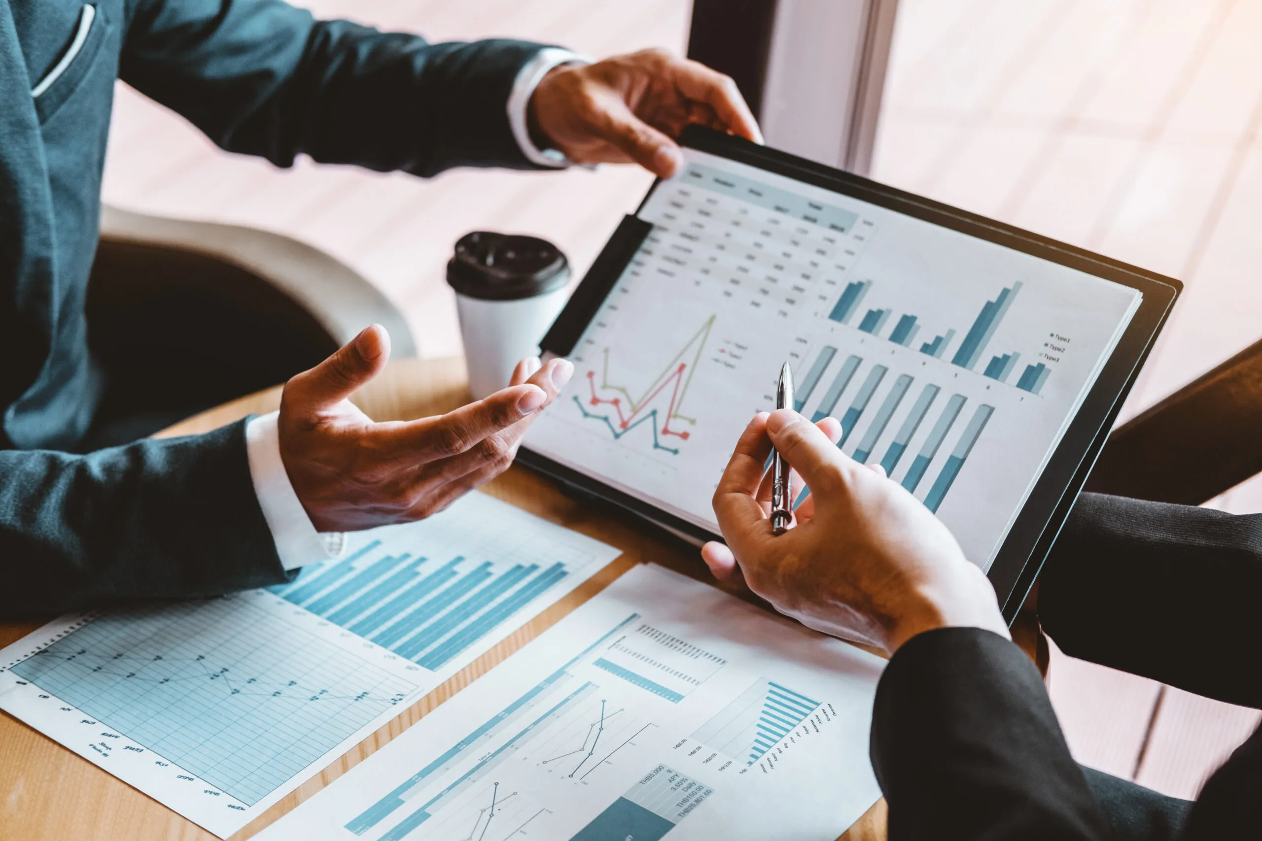 Two people converse over financial spreadsheets.