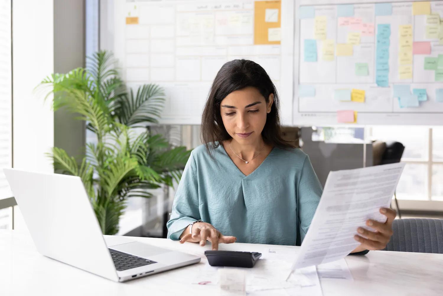 A woman sitting at a desk working on her finances.